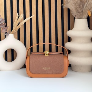 Handcrafted vintage crossbody with fabric flap & gold buckle in cognac – premium vegan leather, stylish and compact, eye‑catcher
