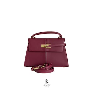 Aria Bag – Trapezförmige Signature-Handtasche aus burgunderfarbenem Veganleder mit Goldverschluss, handverlesen, exklusiv,