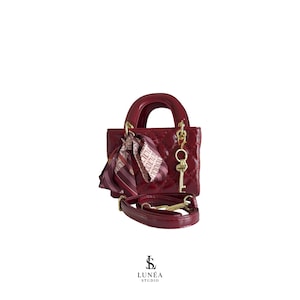Charm Bag – Burgunderrote Mini-Bag mit Steppung, Schleife & Schlüsselanhänger, stylisch, exklusiv, handverlesen, abnehmbarer Riemen