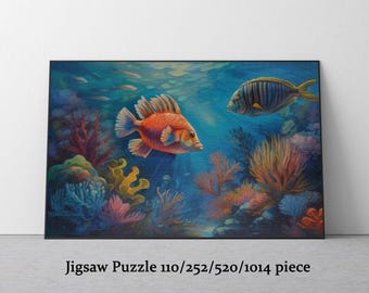 May include: A colorful jigsaw puzzle featuring an underwater scene with two fish and coral. The fish are orange and blue, and the coral is red, yellow, and orange. The text "Jigsaw Puzzle 110/252/520/1014 piece" is at the bottom.