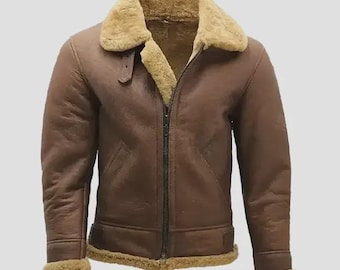 May include: Brown leather jacket with a shearling collar and lining. The jacket features a zip-up front, two front pockets, and shearling trim on the cuffs and hem. A classic bomber style jacket.