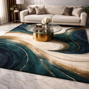 Könnte beinhalten: Ein großer Teppich mit abstraktem Design in Türkis, Marineblau, Beige und Gold. Der Teppich weist ein wirbelndes Muster auf, das ein Gefühl von Bewegung erzeugt. Er befindet sich in einem Wohnzimmer mit einem weißen Sofa und einem Glastisch.