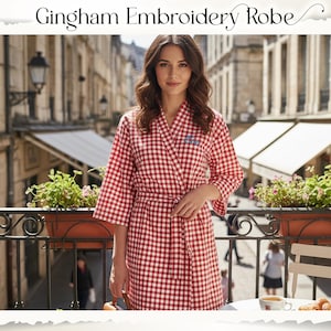 May include: A red and white gingham embroidery robe with a matching belt. The robe has three-quarter sleeves and is worn by a person standing on a balcony. The text "Gingham Embroidery Robe" is at the top of the image.