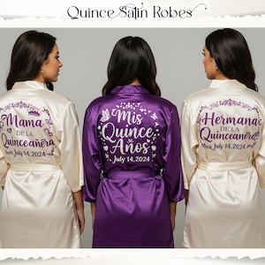 Peut inclure: Trois peignoirs en satin, cr&egrave;me et violet, avec du texte pour une c&eacute;l&eacute;bration de Quincea&ntilde;era. Les peignoirs cr&egrave;me portent l'inscription "Mama de la Quincea&ntilde;era" et "July 14, 2024" au dos. Le peignoir violet porte l'inscription "Mis Quince A&ntilde;os" et "July 14, 2024".