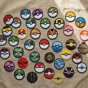 Könnte beinhalten: Eine Sammlung von gestickten Aufnähern mit verschiedenen Designs. Die runden Aufnäher haben eine weiße Mitte und einen schwarzen Rand. Die Designs umfassen verschiedene Farben und Muster, die an Zeichentrickfiguren erinnern.