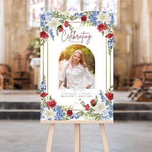 May include: A rectangular memorial sign featuring a central arched photograph of a person in a white shirt, surrounded by a floral border of red roses, blue hydrangeas, and white lilies. The text reads Celebrating the life of Samantha Thomsen.