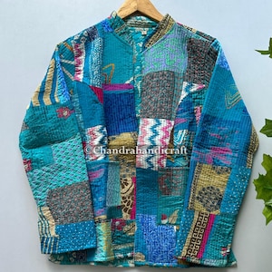 May include: A patchwork jacket in shades of teal, blue, and various other colors. The jacket is made of multiple fabric squares sewn together, creating a unique, textured design. The text "Chandrahandicraft" is visible on the jacket.