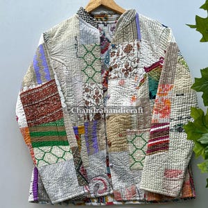May include: A patchwork jacket with a stand-up collar, featuring a variety of fabric patterns and colors. The jacket is quilted and has a button-up front. The color palette includes shades of beige, red, green, and purple.
