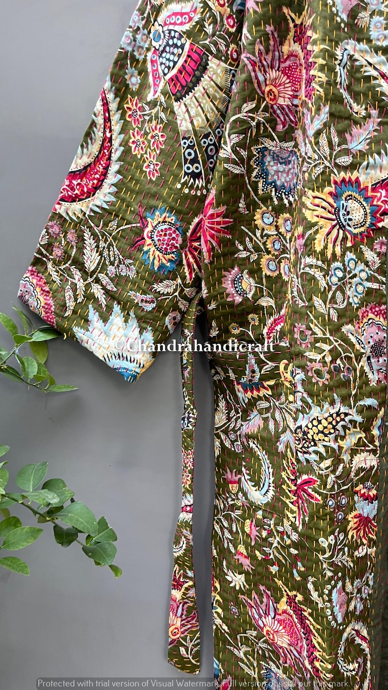 May include: Olive green quilted robe with a vibrant floral pattern in pink, blue, and yellow. The robe features a tie closure and short sleeves. The text "chandrahandicraft" is visible on the robe.