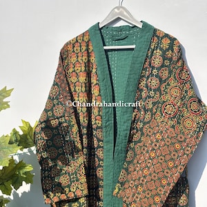 Könnte beinhalten: Gemusterter Bademantel in Grün, Rot und Gelb mit grüner Bordüre, hängt an einem silbernen Kleiderbügel. Der Bademantel hat ein Blumen- und geometrisches Design. Der Text "@Chandrahandicraft" ist sichtbar.