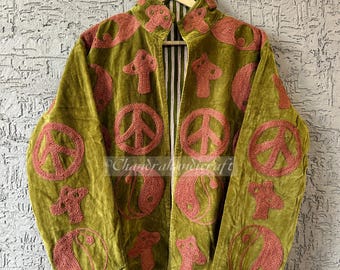May include: Olive green velvet jacket with embroidered pink peace signs, mushrooms, and yin-yang symbols. The jacket has a high collar and a striped lining. The text "Chandrahndicraft" is visible on the jacket.