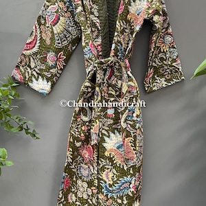 May include: Olive green quilted robe with a floral and paisley pattern in shades of pink, blue, and white. The robe has a belt and is displayed on a hanger. The text "Chandrahandicraft" is visible.