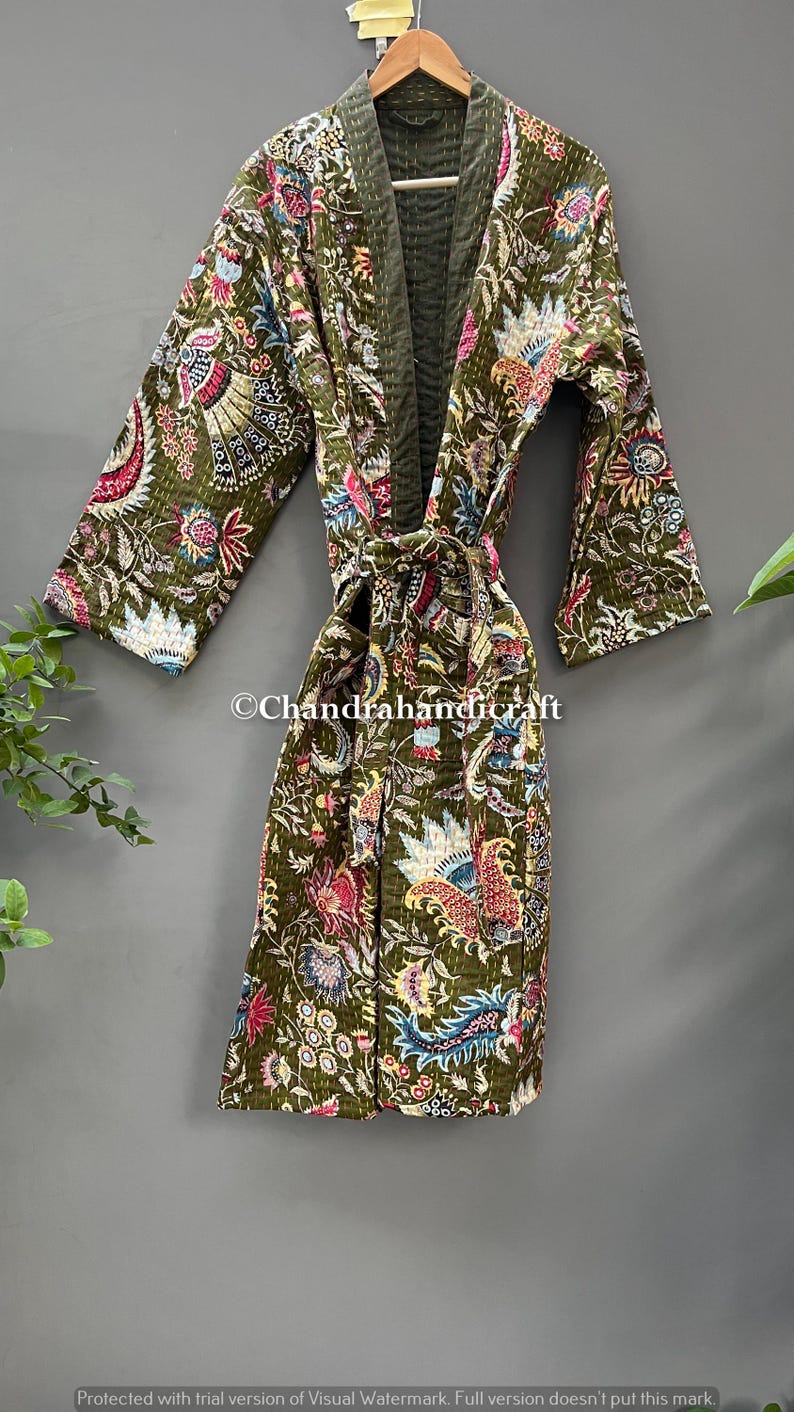 May include: Olive green quilted robe with a floral and paisley pattern in shades of pink, blue, and white. The robe has a belt and is displayed on a hanger. The text "Chandrahandicraft" is visible.