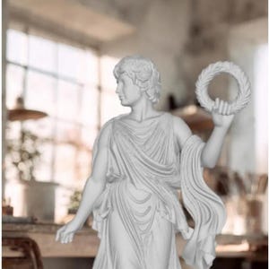 Puede incluir: Estatua blanca de una figura drapeada sosteniendo una corona circular. La estatua presenta rasgos faciales detallados y prendas fluidas. El fondo está borroso, lo que sugiere un entorno interior con luz natural.