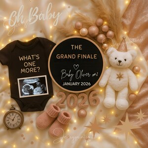 Könnte beinhalten: Baby-Ankündigung mit einem schwarzen Body, Ultraschallbild und einem Schild mit der Aufschrift "The Grand Finale Baby Oliver #2 January 2026". Ein weißer Teddybär und rosa Babysocken sind ebenfalls vorhanden.