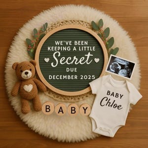 Könnte beinhalten: Eine Ankündigung mit einer grünen Buchstaben-Tafel mit der Aufschrift "We've been keeping a little secret" und "Due December 2025". Enthält einen Teddybären, einen Ultraschall, einen Baby-Body mit dem Namen "Chloe" und Holzbuchstaben "BABY".