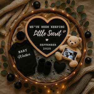Könnte beinhalten: Herzförmige Ankündigungstafel mit dem Text "We've Been Keeping Little Secret September 2025". Ein schwarzer Baby-Body mit "Baby Walker", ein Teddybär mit Ultraschallbild und schwarze Babyschuhe.