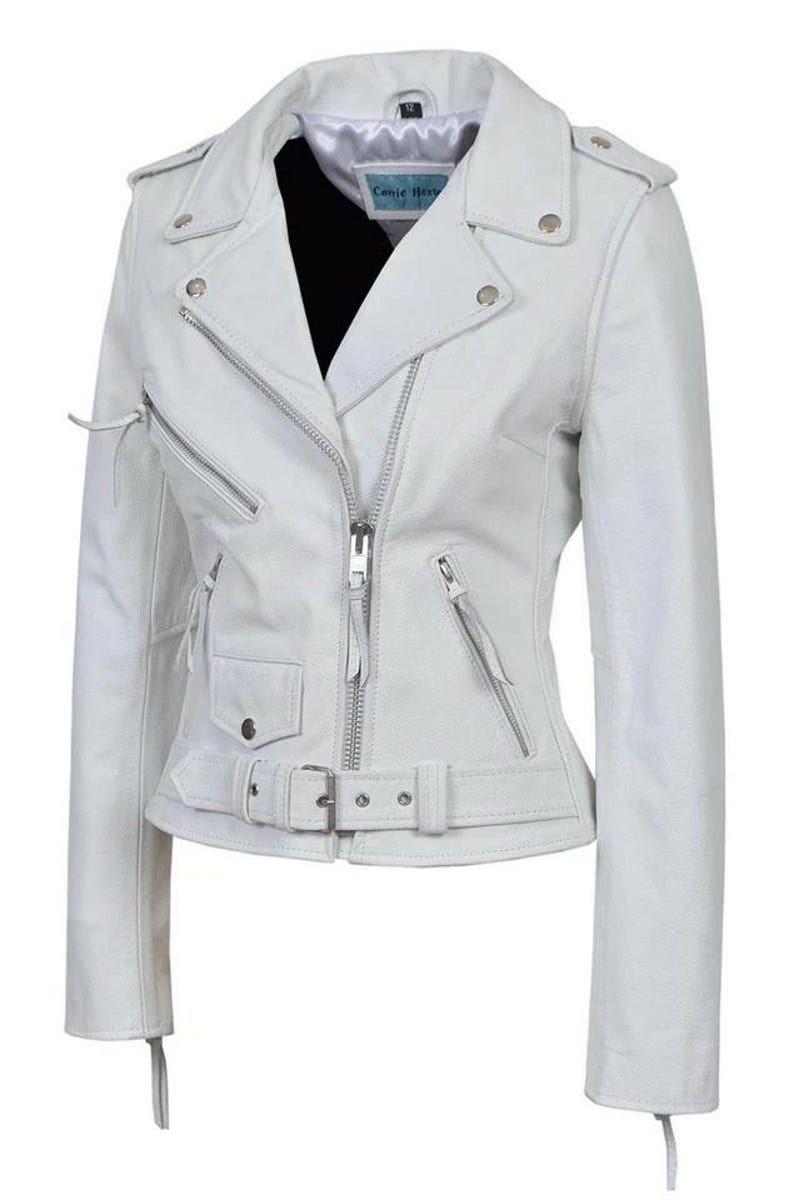 May include: White leather motorcycle jacket with a notched collar, asymmetrical zip closure, and multiple zippered pockets. Features a belt at the waist and silver hardware. The jacket has the text "Carrie Hoxy" on the inside.
