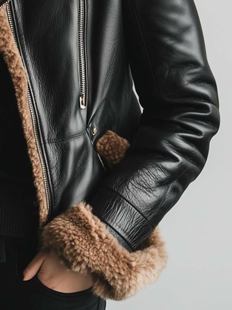 May include: Black leather jacket with brown fur lining and trim. The jacket has a zip closure and a pocket. The sleeves are long with a ribbed cuff. A classic style.
