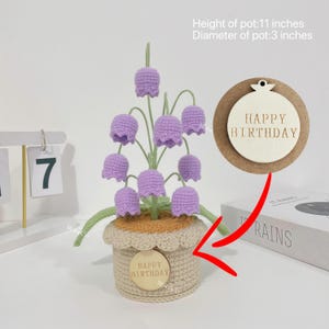 May include: A handcrafted crochet flower arrangement in a beige pot, 11 inches high and 3 inches in diameter, with lavender bell-shaped flowers and green stems. Includes a wooden tag that says "HAPPY BIRTHDAY".