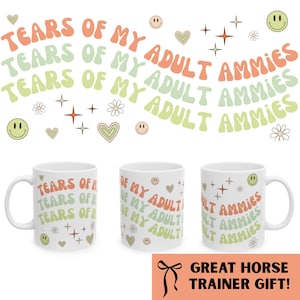 May include: White ceramic mugs with the text "TEARS OF MY ADULT AMMIES" in orange, green, and white. The mugs are decorated with smiley faces, hearts, and stars. The bottom of the image has the text "GREAT HORSE TRAINER GIFT!"