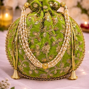 Puede incluir: Un bolso redondo de terciopelo verde lima con cierre de cordón, decorado con bordados metálicos dorados y motivos florales de lentejuelas. Incluye un asa de varias hileras de perlas blancas y pies cónicos de color dorado.