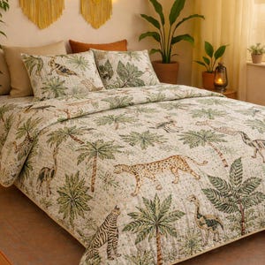 Op de afbeelding: Een bed met een crèmekleurig dekbed en bijpassende kussenslopen met een jungle-thema. Het ontwerp bevat palmbomen, zebra's, luipaarden en andere dieren in het wild in groen, bruin en beige. De kamer heeft gele macramé wandkleden.