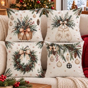 May include: A set of four square throw pillows with a cream background. The designs feature holiday motifs including a basket with pine branches and a bird, hanging mittens with pine, a pine wreath with a bird, and hanging ornaments with pine.