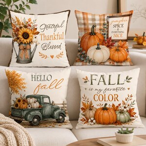 May include: Four square scatter cushions featuring autumn themes. One shows a sunflower pitcher with "Grateful Thankful Blessed," another has pumpkins and "pumpkin SPICE & EVERYTHING NICE," one displays a truck with "HELLO fall," and one has "FALL is my favorite COLOR."