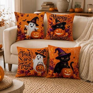 May include: Four square throw pillows featuring Halloween themes on an orange background. Designs include a ghost with a lantern and pumpkin, a black cat in a witch hat with a pumpkin, a ghost with a pumpkin bucket, and a black cat with a pumpkin.