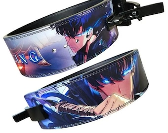 Könnte beinhalten: Zwei Gewichthebergürtel mit schwarzem Hintergrund und einer farbenfrohen Grafik im Anime-Stil. Die Grafik zeigt eine Figur mit blauen Augen und einem Schwert. Die Gürtel haben eine schwarze Schnalle.