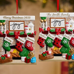 May include: Christmas ornament shaped like a fireplace with stockings and the word "joy". The ornament has the text "Merry Christmas 2025" and "The Smith Family". Stockings are personalized with names.