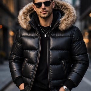 Puede incluir: Chaqueta acolchada negra con capucha ribeteada de piel. La chaqueta tiene un aspecto brillante y acolchado y cierre de cremallera. La persona de la imagen lleva gafas de sol y un collar plateado. Una elegante prenda de abrigo.