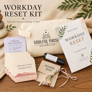Könnte beinhalten: Ein Workday Reset Kit bestehend aus einem beigen Stoffbeutel mit Soulful Pause Logo, einem Journal mit dem Titel Workday Reset, Anleitungskarten, einem kleinen ätherischen Öl-Roll-on und einer Perlenkette in einem kleinen beigen Umschlag.