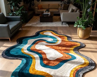 May include: A modern area rug with an abstract design. The rug features a wavy, organic shape with layers of color including teal, orange, yellow, and white. The rug is placed on a hardwood floor in a living room setting.