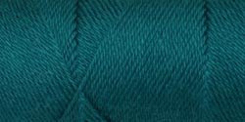 May include: Teal yarn with a soft, textured appearance. The yarn is tightly wound and shows the individual strands.