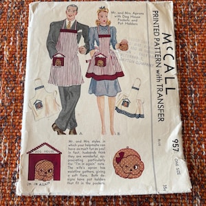 Puede incluir: Patrón de costura vintage McCall's para delantales. El patrón presenta ilustraciones de un hombre y una mujer que usan delantales con bolsillos de caseta para perros y agarraderas. El texto incluye "Mr. and Mrs. Aprons" y "Printed Pattern with Transfer".
