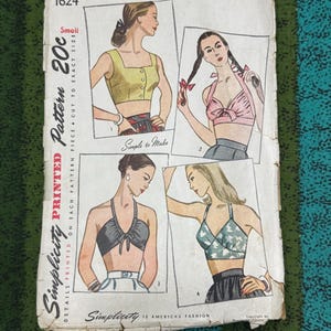 May include: A vintage Simplicity 1624 sewing pattern envelope featuring four illustrations of crop tops. The white paper cover displays the text Simplicity Printed Pattern 20c, 1624, and Small. The illustrations show various halter and button-front styles.