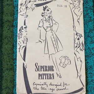 Op de afbeelding: Vintage naaipatroon getiteld "Superior Pattern" met een tekening van een jurk. Het patroon is maat 14 en bevat de tekst "Especially designed for the teen-age crowd."