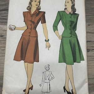 Op de afbeelding: Vintage naaipatroon voor een tweedelige jurk met een getailleerd lijfje en een volle rok. Het patroon is voor maat 14, borstomvang 81 cm. De jurk is in twee kleuren getoond: bruin en groen.