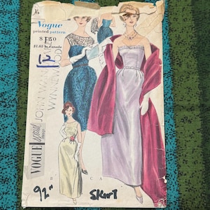 Pode incluir: Padrão impresso vintage da Vogue com ilustrações de elegantes vestidos de noite. O padrão inclui um vestido sem alças com um xale, um vestido de renda azul e um vestido justo. O texto no padrão diz "Vogue special design John Wan Wynnewood".