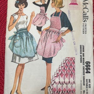 Pode incluir: Um padrão de costura vintage McCall's para um avental smocked. O padrão é para os tamanhos 9-16 e é feito de vichy xadrez. O padrão é ilustrado com três mulheres usando o avental em diferentes cores.