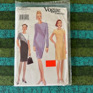 May include: A Vogue Patterns sewing pattern packet, sealed in plastic. The packet features illustrations of three dresses. The text on the packet reads "9697 PATTERN/PATRON S-10-12" and "Vogue Patterns".
