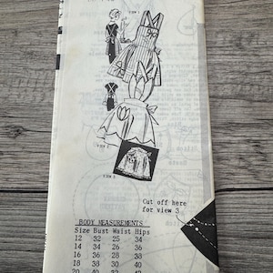 May include: Vintage sewing pattern with illustrations of an apron. The pattern includes body measurements and instructions. The text on the pattern reads "1-461 This PHOT" and "SIZE 40 BUST 42". The pattern is on a light-colored paper.