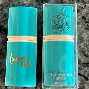 Puede incluir: Dos frascos de spray de perfume turquesa. Uno tiene las palabras "toujours moi" en escritura dorada. El otro tiene un diseño de unicornio y las palabras "LIGHT PERFUME SPRAY .10 FL. OZ."