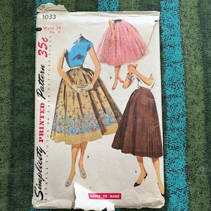 May include: Vintage Simplicity sewing pattern featuring illustrations of skirts. The pattern envelope is off-white with text and illustrations in blue, brown, and pink. The text includes "Waist 24, Hip 33" and "Simple to Make."