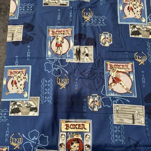 Könnte beinhalten: Blauer Stoff mit einem sich wiederholenden Muster von Illustrationen zum Thema Boxen. Das Design umfasst Bilder von Boxern, Boxhandschuhen und dem Wort "BOXER" in verschiedenen Rahmen. Florale und geometrische Elemente sind ebenfalls vorhanden.
