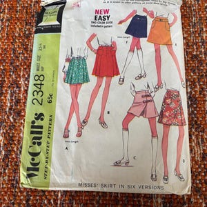 Puede incluir: Patrón de costura vintage McCall's 2348 para faldas de mujer en seis versiones. El sobre del patrón presenta ilustraciones de los diseños de faldas, con texto que indica la talla de cintura 65 cm y cadera 91 cm. Incluye una guía de dos colores.