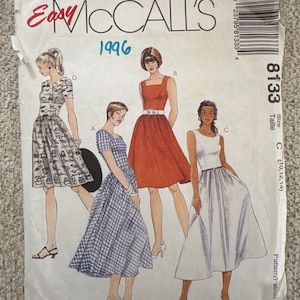 May include: A vintage McCall's sewing pattern from 1996, featuring illustrations of four different dress designs. The pattern cover is white with red and blue text, and includes a barcode and size information.