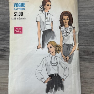 May include: Vintage Vogue pattern envelope with blouse illustrations. The off-white envelope has black and red text and illustrations. The pattern size is 10, with bust 82.5 cm and hip 87.6 cm.